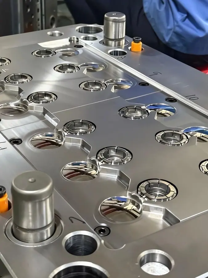 Close view of multi-cavity cap-mold tooling on the factory floor