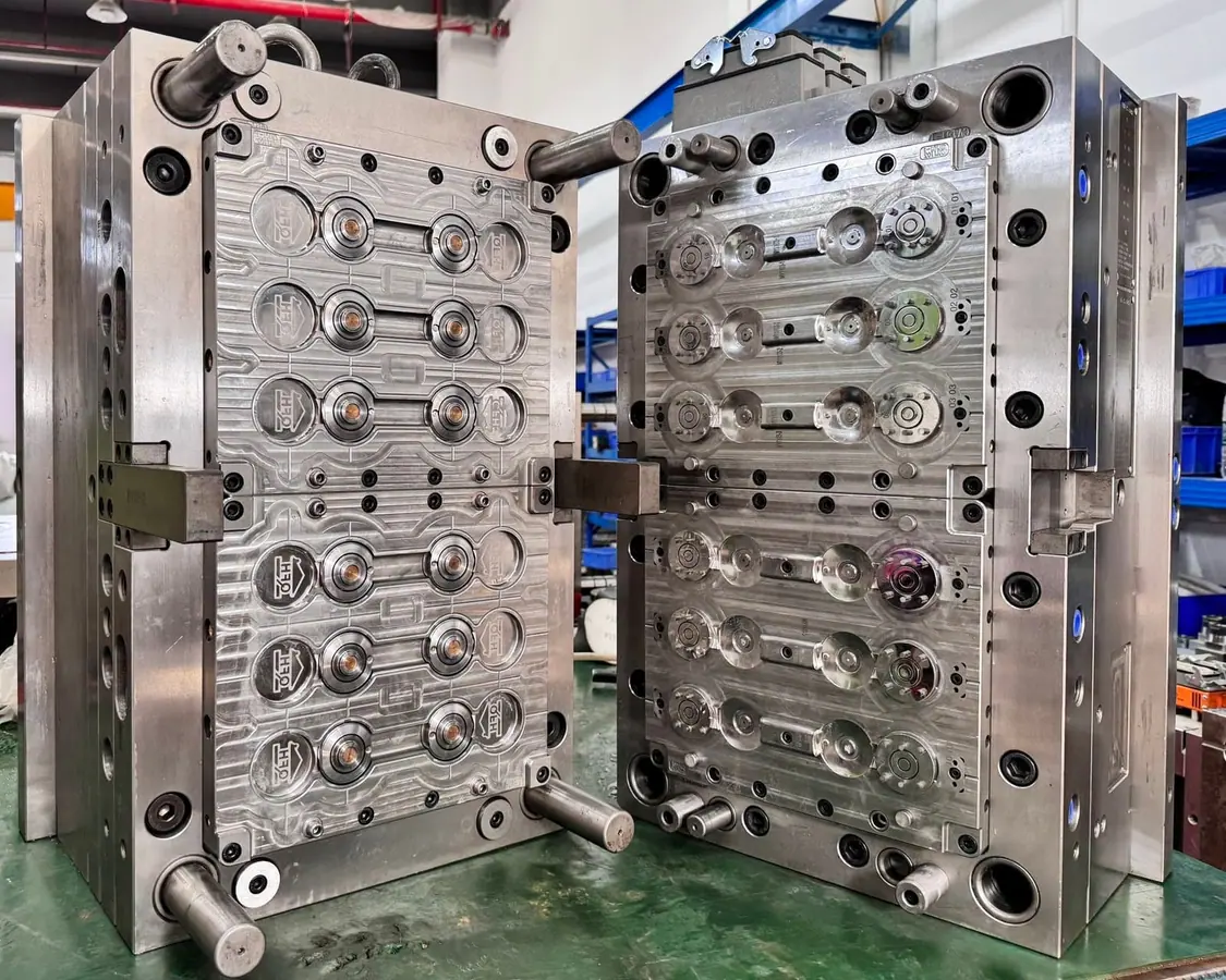 Open cap-mold tooling with a visible multi-cavity layout
